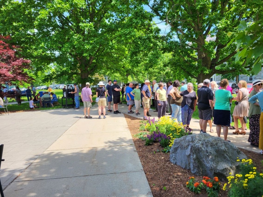 Employees standing in line in the sun