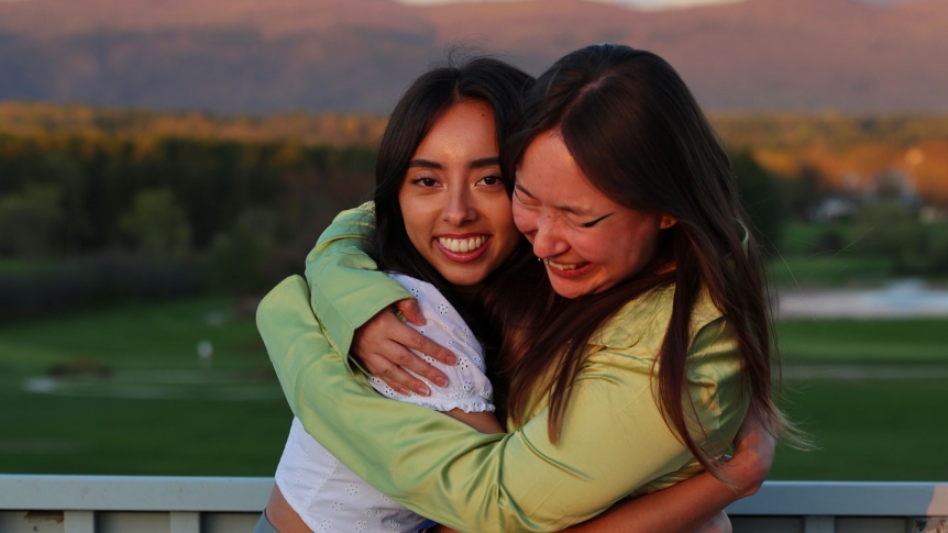 Two graduates hugging.