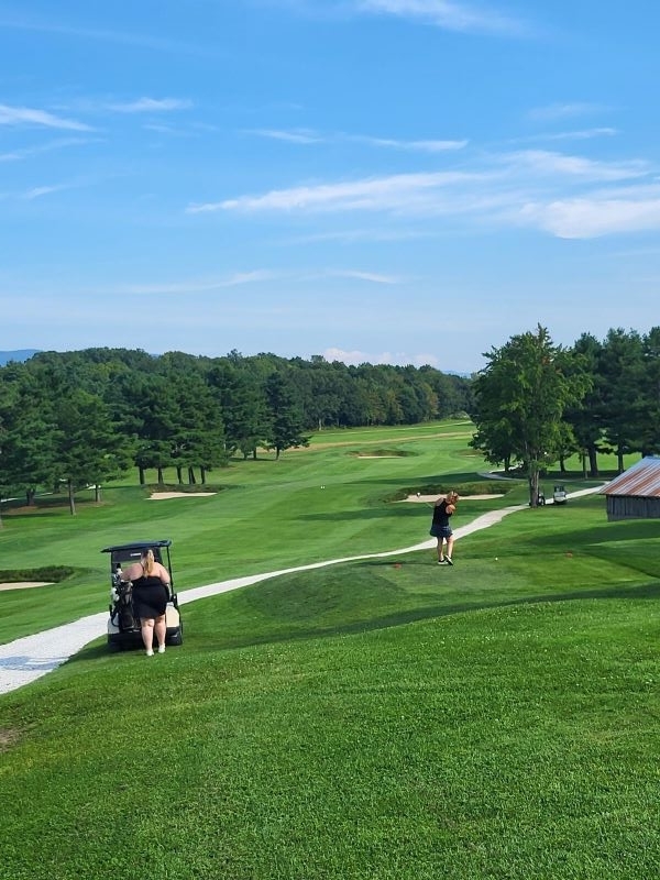 Colleagues standing together playing golf