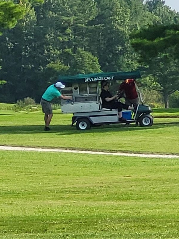 Beverage cart serving golfer