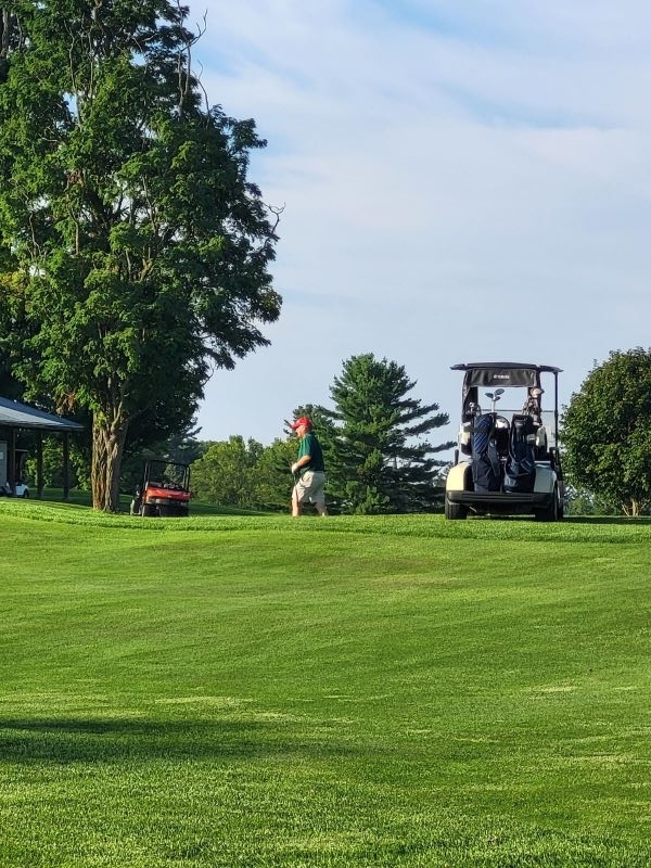 Colleagues standing together playing golf