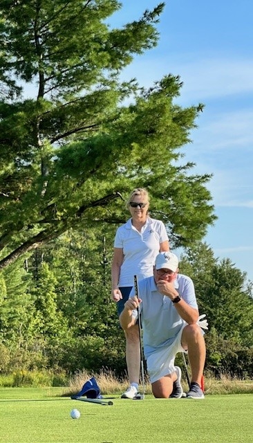 Colleagues standing together playing golf