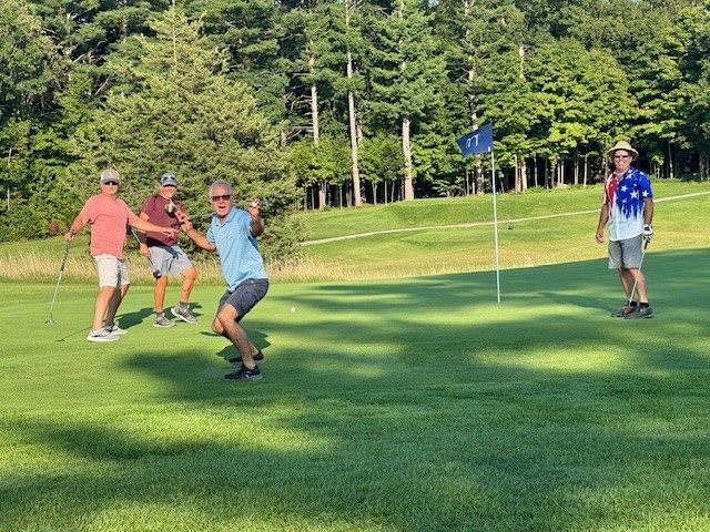 Colleagues standing together playing golf