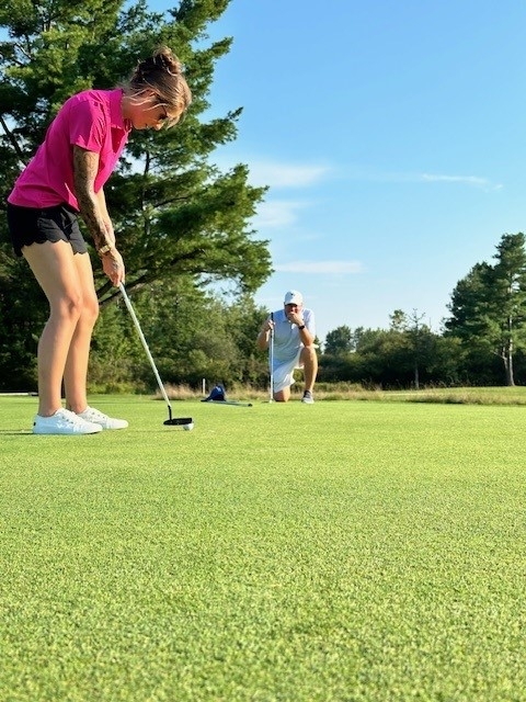 Colleagues standing together playing golf