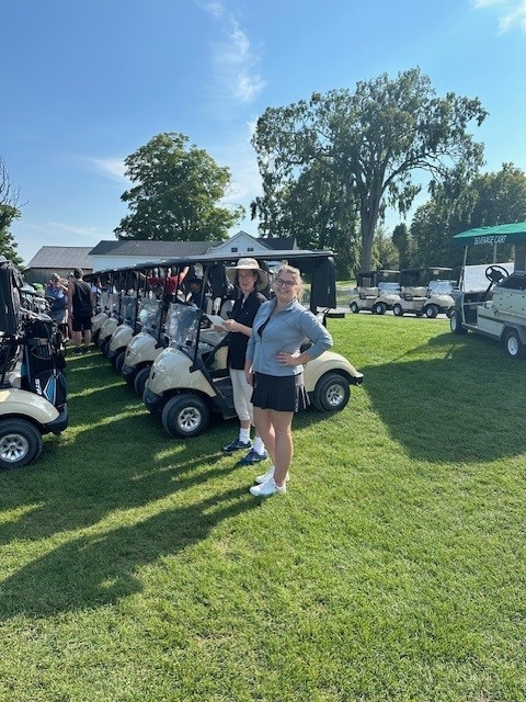 Colleagues standing together playing golf