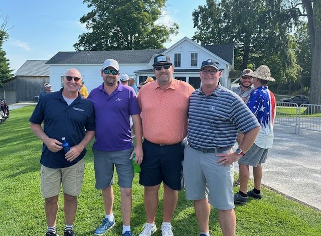 Colleagues standing together playing golf