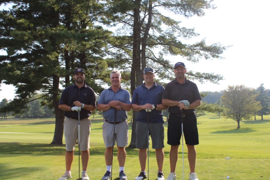 Colleagues standing together playing golf