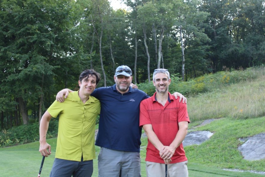 Colleagues standing together playing golf