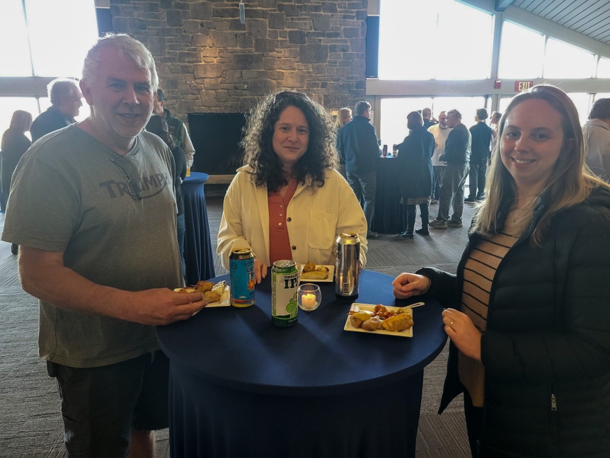 Colleagues standing together around a small table smiling
