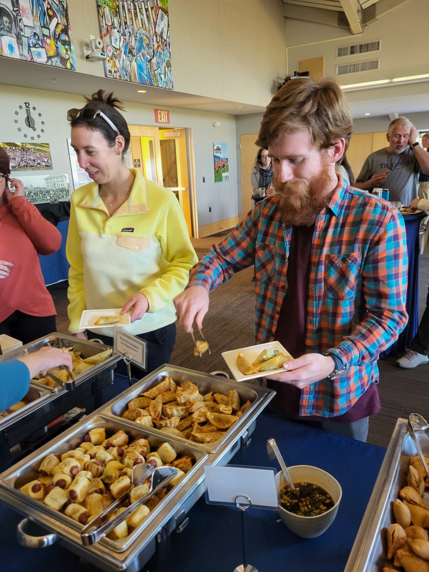 Colleagues going through buffet line to get food