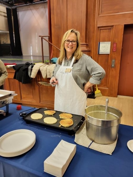 Employee smiling cooking pancakes