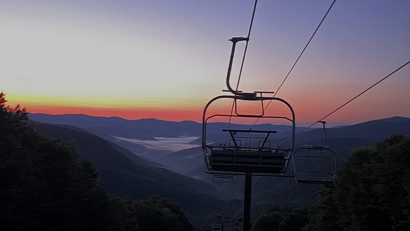 Chair lift looking over mountains at sunset