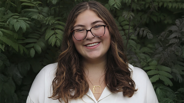 Portrait of Kristen Watkins ’23.5 against a green foliage background.