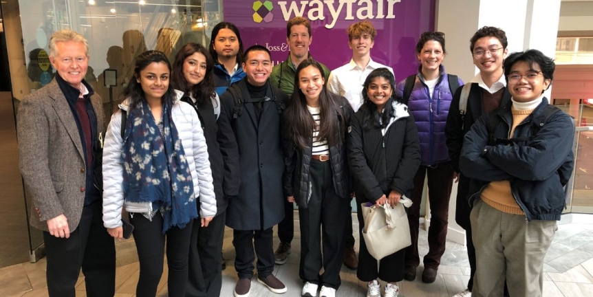 Middlebury students posing in front of the Wayfair sign during a Student Trek