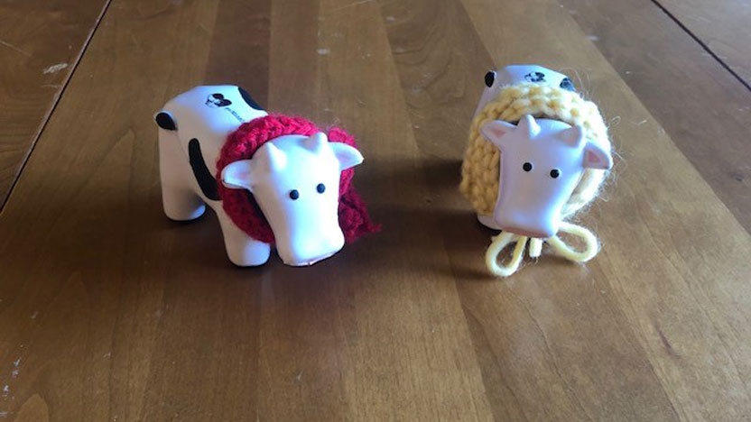 Two ceramic cows with scarves knotted around their necks.