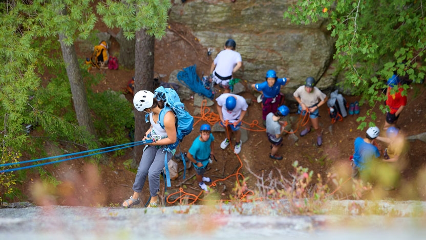 Group of student belaying down a cliff.