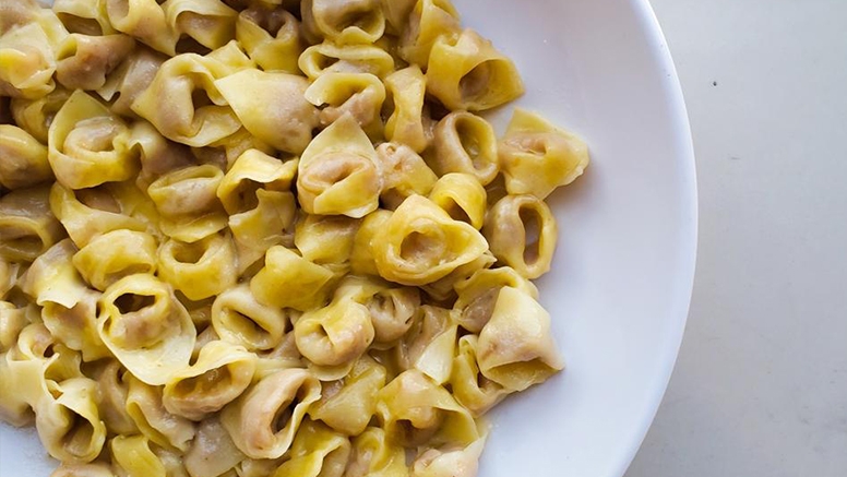 Top-down view of pasta in white bowl on marble counter