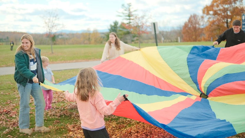 Students and young children playing.