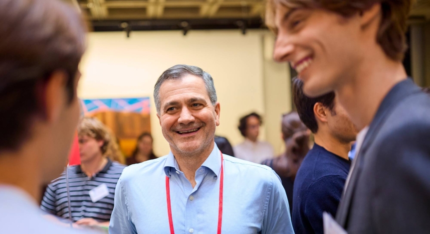 A parent speaks with two students.