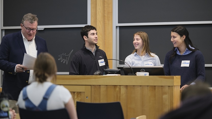 Three students present alongside their community partner in the community-connected Statistical Consulting course.