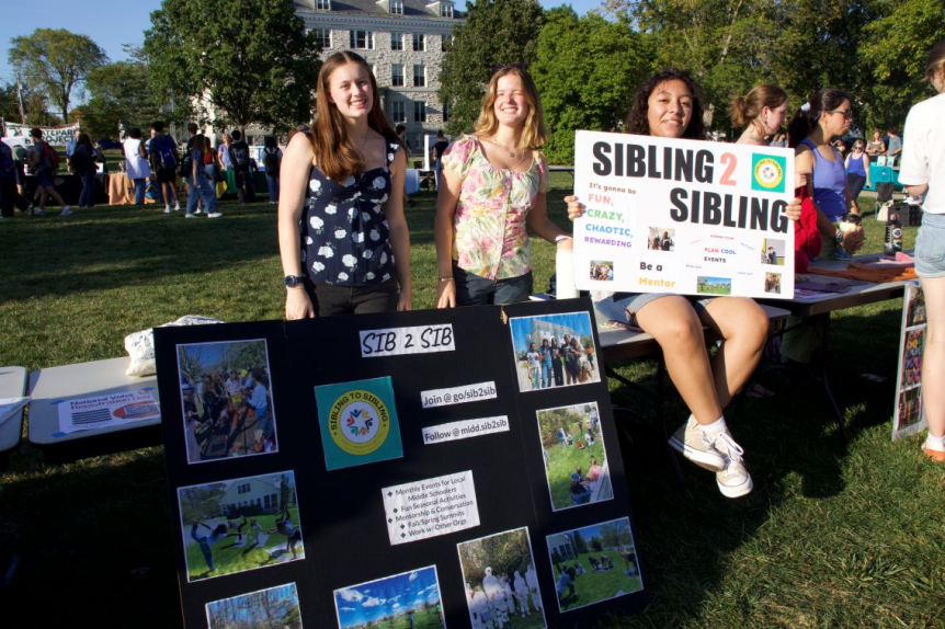 Three Sib2Sib volunteers at outdoor tabling event smile for the camera.