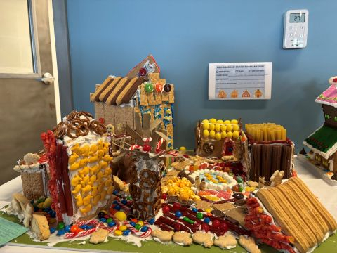 Large, colorful gingerbread house creation with various foods