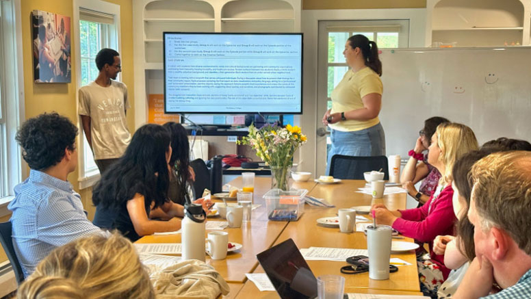 Two people making a presentation with a screen to a classroom.