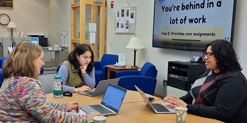 staff and students working at a table