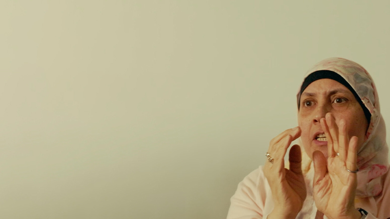 An older woman in a hijab practicing self defense.