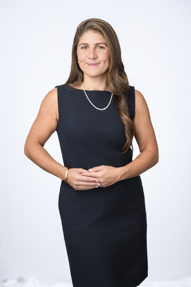 A person poses for the camera with a slight but confident smile.