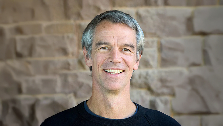 Portrait of Andrew Mahlstedt ’98 against a stone background.