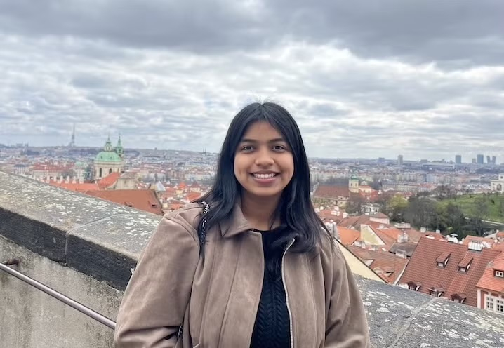 Person standing outside looking at the camera and smiling.