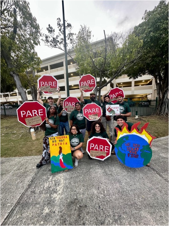 Group of students holding climate justice protest signs shaped like stop signs