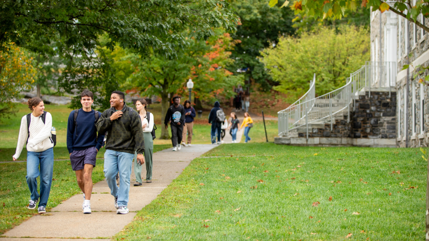 Students walk across main quad in front of Munroe Hall.