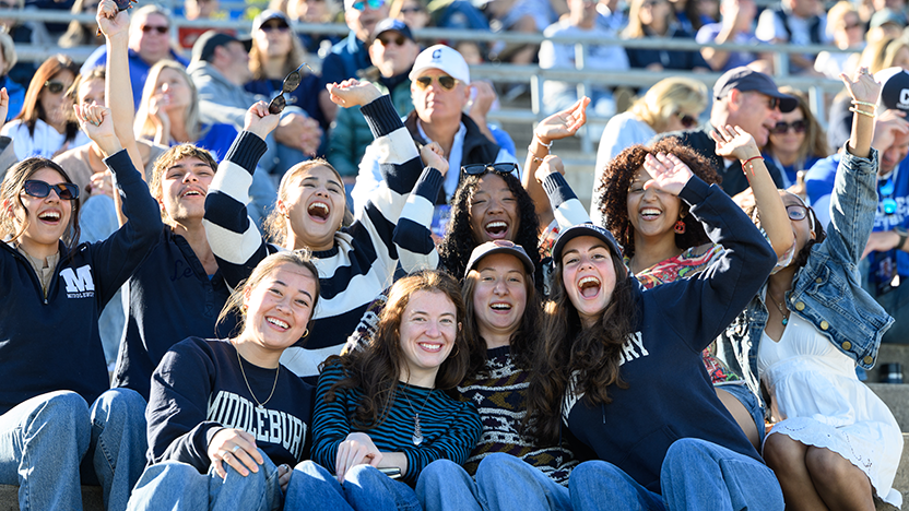 A group of friends cheering on the Panthers at the Homecoming football game