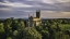 aerial view of gothic cathedral among green trees against a cloudy sky
