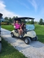 Two colleagues driving golf cart