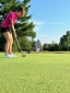 Colleagues standing together playing golf