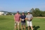 Colleagues standing together playing golf