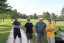 Colleagues standing together playing golf