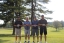 Colleagues standing together playing golf