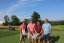 Colleagues standing together playing golf