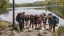 Students on a backpacking trip pause by a lake.