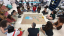 A group of students sitting around a piece of brown paper co-creating a conceptual body map of Puerto Rico