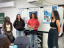 Four students stand in front of posters presenting sketches for press releases