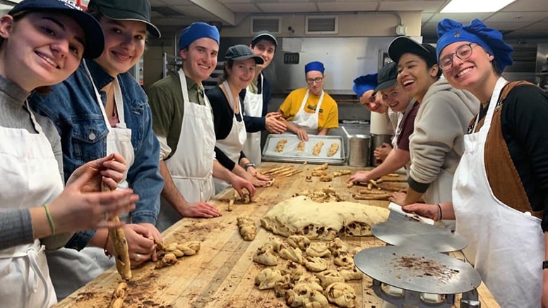 Several Middlebury students bake Challah in a kitchen on campus.