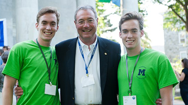 Jim Keyes and his two children Jared and David, smiling outside Mead Chapel