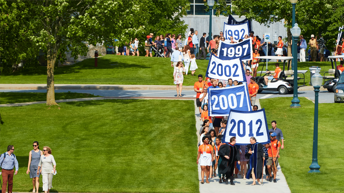 Convocation parade at Reunion, with banners from classes between 2012-1992 visible