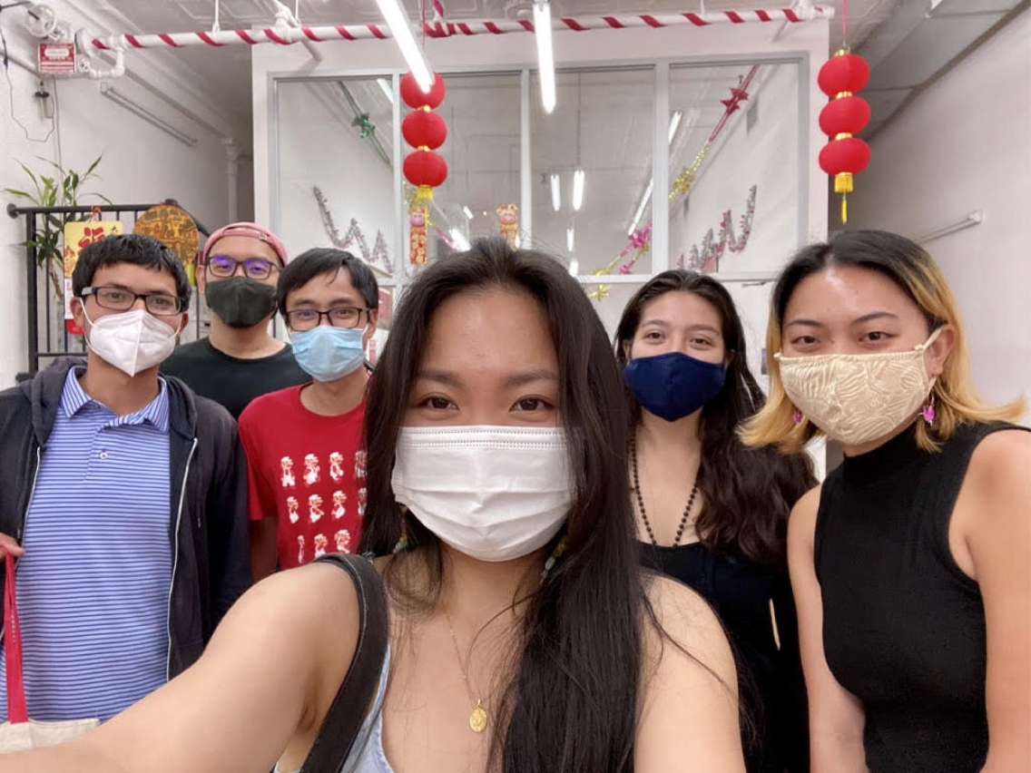 Sabrina Lin poses for a selfie in a mask with five other people also wearing masks.