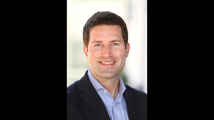 headshot of Philipp Bleek in black jacket and light blue buttoned shirt